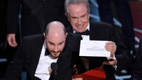 Jordan Horowitz, producer of La La Land, shows the envelope revealing Moonlight as the true winner of best picture at the Oscars on Sunday, Feb. 26, 2017, at the Dolby Theatre in Los Angeles. Presenter Warren Beatty looks on from right. 89th Academy Awards - Show