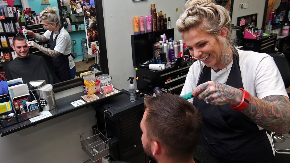 Hair stylist Jamie Feramisco shares a laugh with a client at Pin-Up Hair Studio in Quincy, Illinois. In January 2017, an Illinois law took effect that mandates training for stylists like Feramisco so they can support people affected by domestic violence.