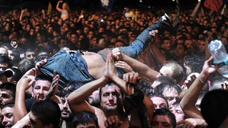 A fan who was dancing in the mosh pit is lifted to remove him from the area, toward security, during Argentine singer Indio Solari's show in Olavarria, Argentina, Saturday, March 11, 2017. Officials say two people died in a crush during Solari's massive rock concert. Argentina Concert Deaths