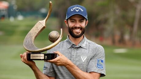 Adam Hadwin holds up the champion's trophy after winning the Valspar Championship golf tournament Sunday. hadwin-adam