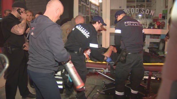 Toronto paramedics attend to a man who was assaulted outside a club and restaurant on Queen West Street early Saturday.