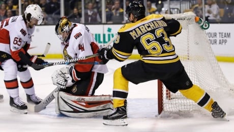 Boston's Brad Marchand tries to knock the puck away from Ottawa goaltender Craig Anderson Tuesday during the Senators' 3-2 win. Senators Bruins Hockey