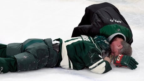 Minnesota's Zach Parise (11) is looked at by a trainer after a high stick to the face by Washington's Tom Wilson Tuesday. Parise will miss three games because of injury. Capitals Wild Hockey