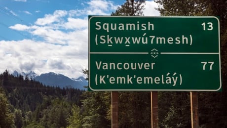 A bilingual roadside mileage sign is shown along the Sea to Sky Highway in Squamish, British Columbia. The signs have been erected written in both English and the language of the Squamish and Lil'Wat First Nations bands who traditionally lived in the area between Vancouver and Whistler. British Columbia Road Sign