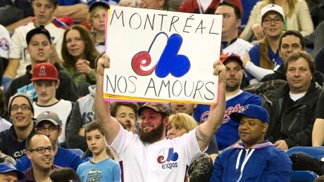 Fans wear Montreal Expos uniforms as they watch the Toronto Blue Jays in a pre-season baseball game against the New York Mets Friday, March 28, 2014 in Montreal.THE CANADIAN PRESS/Ryan Remiorz expos-fans-140328-1180