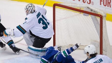 San Jose Sharks' goalie Martin Jones, left, fights to make a save while Vancouver Canucks' Griffen Molino crashes into the net during the second period on Sunday. Jones-Martin-04022017