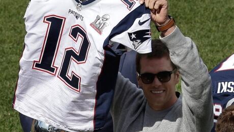 Patriots quarterback Tom Brady displays his recovered jersey during pre-game ceremonies before the Red Sox-Pirates season opener in Boston on Monday. The 2017 jersey was stolen from the dressing room after New England's February Super Bowl victory over Atlanta. brady-tom-170403-1180