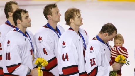 Canada's Eric Lindros, Rob Blake, Chris Pronger and Joe Nieuwendyk holding his daughter Tyra, stand for the national anthem following their 5-2 Olympic gold medal win over USA in men's hockey at the 2002 Olympic Winter Games. lindros-prongers