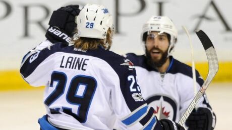 Winnipeg Jets' Patrik Laine (29) is congratulated by teammate Mathieu Perreault, right, after his second goal against the St. Louis Blues. jets-blues