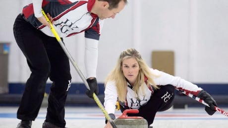 Brent Laing sweeps for teammate Jennifer Jones in the Wall Grain Mixed Doubles Curling Classic at the Oshawa Curling Club in Oshawa, Ont. on Monday, November 116, 2015. THE CANADIAN PRESS/Frank Gunn jones-laing-1180