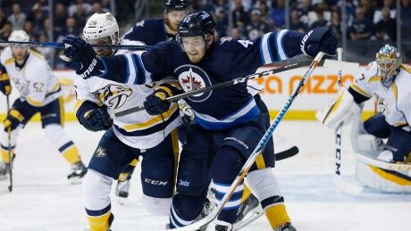 Winnipeg's Joel Armia (40) chases down a loose puck, while battling Nashville's Harry Zolnierczyk during the Jets' 2-1 win over the Predators on Saturday in Winnipeg. Jets-Predators-08042017