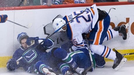 Edmonton Oilers defenceman Darnell Nurse, right, collides with two Vancouver Canucks in Edmonton's 3-2 victory on Saturday. Nurse-Darnell-04082017