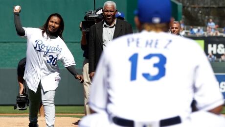 Marisol Hernandez, mother of deceased pitcher Yordano Ventura, throws out the first pitch as Ventura's grandfather Raul Hernandez watches prior to the Royals' home opener against the Oakland Athletics at Kauffman Stadium on Monday. 95303606