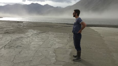 Geoscientist Dan Shugar gazes out over exposed sediments and dust storms at Kluane Lake in the Yukon in summer of 2016. Covered in water just months before, the delta top was left exposed and prone to wind erosion after meltwater from the Kaskawalsh Glacier changed directions due to climate change, the first documented case of a phenomenon known as 'river piracy' in modern times. climate-change-yukon-river-piracy-dan-shugar