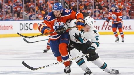 Justin Braun, right, of the San Jose Sharks battles for the puck against Zack Kassian of the Edmonton Oilers during Game 2 of their NHL playoff series on Friday. Oilers-Sharks-14042017