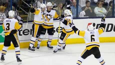 Pittsburgh Penguins forward Jake Guentzel, middle, celebrates his game-winning goal with teammates during the first overtime period in Game 3 against the Columbus Blue Jackets on Sunday in Columbus. The Penguins defeated the Blue Jackets 5-4. penguins-041617-620