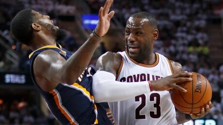 Cleveland's LeBron James drives through Indiana's Paul George during the Cavaliers' 117-111 win in Game 2 of their first-round playoff series Monday. 95353899