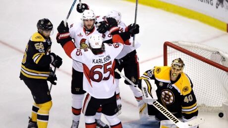 Ottawa Senators right wing Bobby Ryan, facing, celebrates with teammates after his game-winning goal past Boston Bruins goalie Tuukka Rask. senators-ottawa