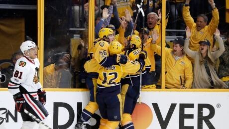 Chicago Blackhawks' Marian Hossa skates to the bench as Nashville Predators left wing Kevin Fiala (56) celebrates his game-winning overtime goal to give Nashville a 3-0 series lead over Chicago. predators-nashville