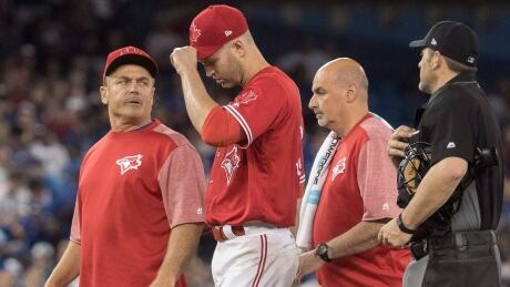 Toronto Blue Jays manager John Gibbons (left) walks with starting pitcher J.A. Happ to the dugout after he was forced to leave Sunday's game against the Baltimore Orioles with an injury. J.A.-Happ-DL