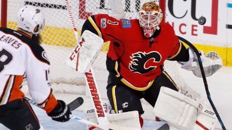 Calgary Flames goalie Brian Elliott, right, makes a save against the Anaheim Ducks' Patrick Eaves during first period of Monday's game. ducks-flames