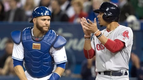 Boston Red Sox's Mookie Betts scores on a double by Hanley Ramirez as Toronto Blue Jays catcher Russell Martin looks during Tuesday's 8-7 Boston win. Toronto fell to 2-11. jays-red-sox