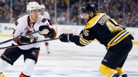 Boston Bruins' Joe Morrow (45) and Ottawa Senators' Kyle Turris (7) battle for the puck during the first period. sens-bruins