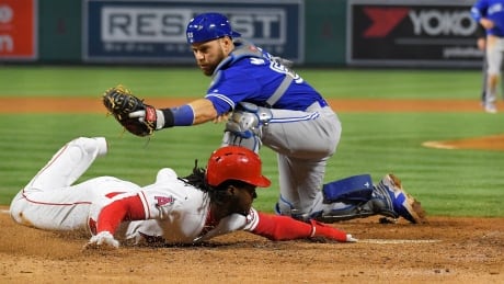 Los Angeles Angels' Cameron Maybin scores as Toronto Blue Jays catcher Russell Martin makes a late tag during the fifth inning of Monday's 2-1 Angels win. Blue Jays Angels Baseball