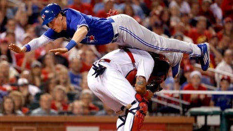 Toronto Blue Jays' Chris Coghlan leaps over St. Louis Cardinals catcher Yadier Molina to score during the seventh inning on Tuesday night. jays-cardinals