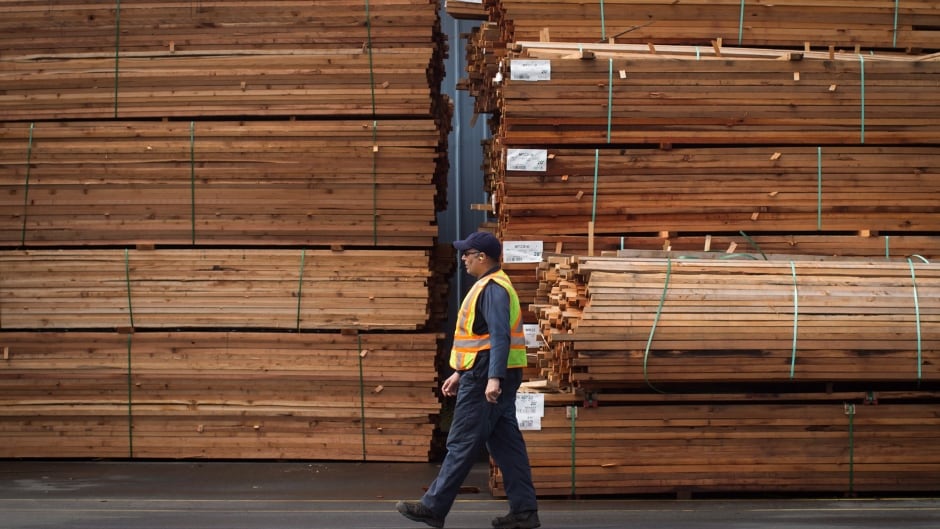 A worker walks past stacks of lumber at the Partap Forest Products mill in Maple Ridge, B.C., on Tuesday April 25, 2017.