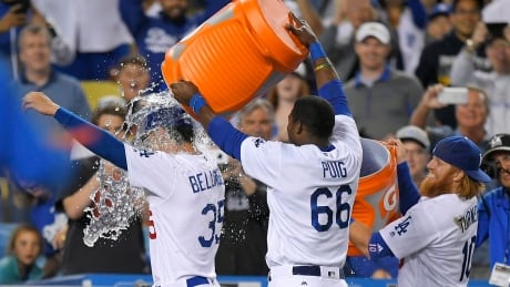 Los Angeles Dodgers' Cody Bellinger, left, is doused with liquid by Yasiel Puig, centre, and Justin Turner after the Dodgers defeated the Philadelphia Phillies 6-5 on Saturday. Phillies Dodgers Baseball