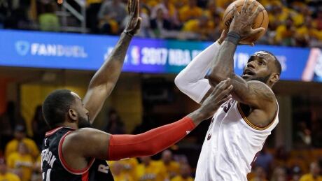 Cleveland's LeBron James, right, drives to the basket against Toronto's Patrick Patterson during the Cavaliers' 116-105 win in Game 1 Monday. Raptors Cavaliers Basketball