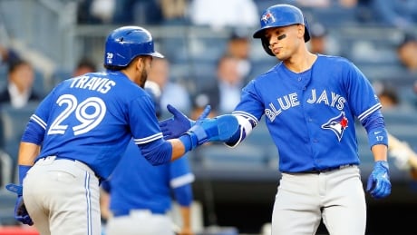 Toronto's Ryan Goins is congratulated by teammate Devon Travis after Goins' two-run home run gave the Jays an early lead against the Yankees. Goins had four RBI in Toronto's 7-1 win Monday. 95591998