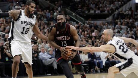 Houston Rockets guard James Harden (13) drives between San Antonio Spurs forward LaMarcus Aldridge (12) and guard Manu Ginobili (20) during the first half of Game 1. rockets-spurs