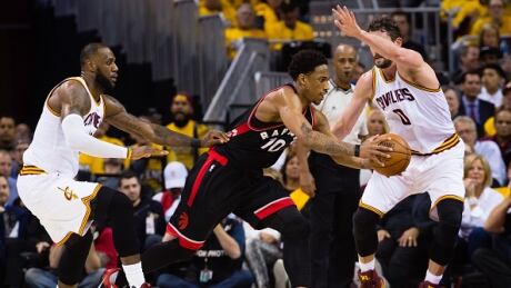 Toronto Raptors' DeMar DeRozan drives around Cleveland Cavaliers' LeBron James and Kevin Love during the second half of Game 1. raptors-cavaliers