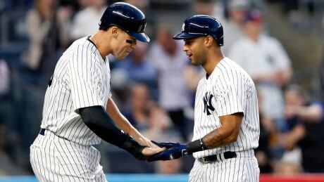 New York Yankees Aaron Judge, left, greets teammate Aaron Hicks after Hicks hit a two-run home run off Toronto Blue Jays starting pitcher Mat Latos Tuesday. blue-jays-yankees