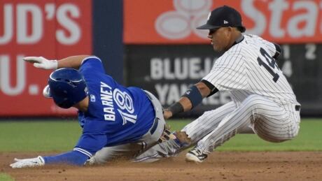 Toronto Blue Jays' Darwin Barney, left, slides into second base with a double as New York Yankees second baseman Starlin Castro (14) applies the late tag during the second inning on Wednesday at Yankee Stadium in New York. blue-jays-050317-620