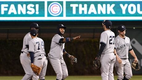 Yankees’ second baseman Starlin Castro, middle, celebrates with catcher Austin Romine, right, after driving in the winning run in the 18th inning for a 5-4 victory over the Cubs in Chicago. (David Banks/Getty Images) castro-starlin-170508-1180