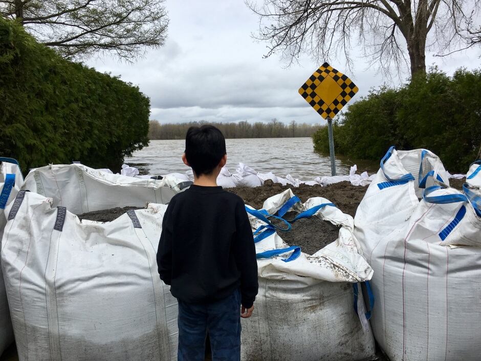 Boy in Pierrefonds behind sandbags