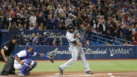 With the crowd still on its feet for a welcoming ovation, Edwin Encarnacion hits a single Monday in his first at-bat against his former Jays teammates since signing with Cleveland in the off-season. 95703985