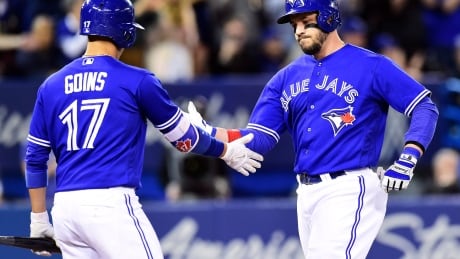 Toronto Blue Jays outfielder Steve Pearce, right, is congratulated by teammate Ryan Goins after hitting a three-run home run against the Seattle Mariners during fifth inning in Toronto on Thursday. blue-jays-051117-620