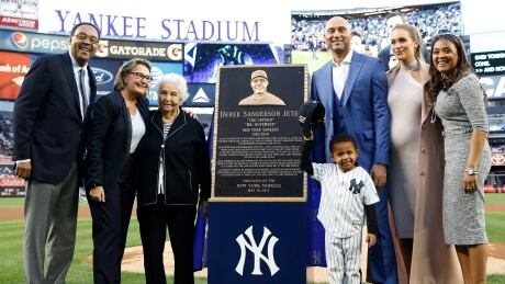 Retired New York Yankees shortstop Derek Jeter, third from right, poses with members of his family during a pregame ceremony retiring his number in Monument Park at Yankee Stadium. yankees-jeter