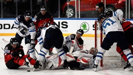 Canada's Mitch Marner, left, and Finland goaltender Harri Sateri scramble for the puck during Canada' s 5-2 win Tuesday at the world championship tournament in Paris, France. AFP_OG9LZ