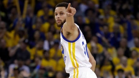 Golden State Warriors' Stephen Curry signals after scoring against the San Antonio Spurs during the first half of Game 2. spurs-warriors