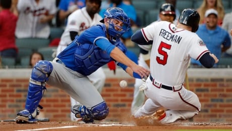 Atlanta's Freddie Freeman scores as the ball gets away from Toronto catcher Luke Maile during the Braves' six-run first inning Wednesday. Blue Jays Braves Baseball