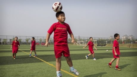 The risks of heading a soccer ball for youths such as this young Chinese boy remain unclear, says UEFA. soccer-kid-051817