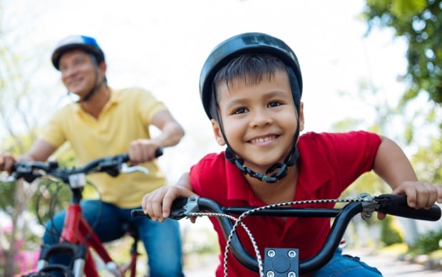 Kid riding bicycle with parent
