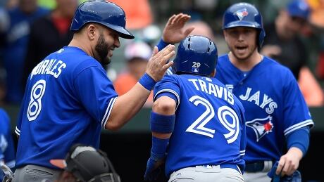 Toronto Blue Jays' Devon Travis, centre, is congratulated by Kendrys Morales, left, and Justin Smoak after hitting a three-run home run against the Baltimore Orioles in the first inning on Sundayin Baltimore. blue-jays-052117-620