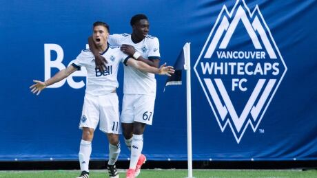 Vancouver Whitecaps' Nicolas Mezquida, left, and Alphonso Davies celebrate Mezquida's goal against the Montreal Impact. impact-whitecaps