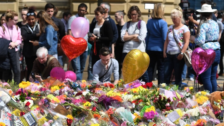 People look over floral tributes in St. Ann's Square for the people who lost their lives during the Manchester terror attack in central Manchester, Britain, 24 May 2017.